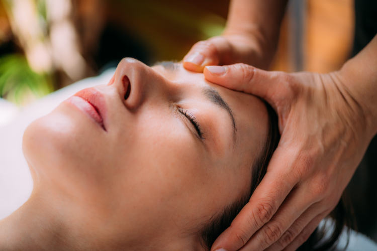 Physical therapist easing migraine pain with gentle forehead pressure