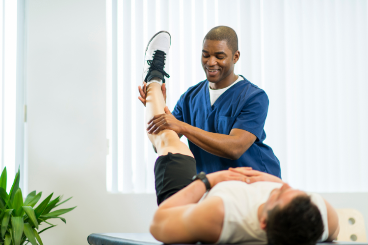 Physical therapist assisting patient with hands-on leg rehabilitation