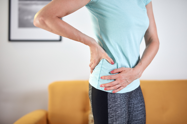 Woman Holding Hip Experiencing Pain Relief Through PT